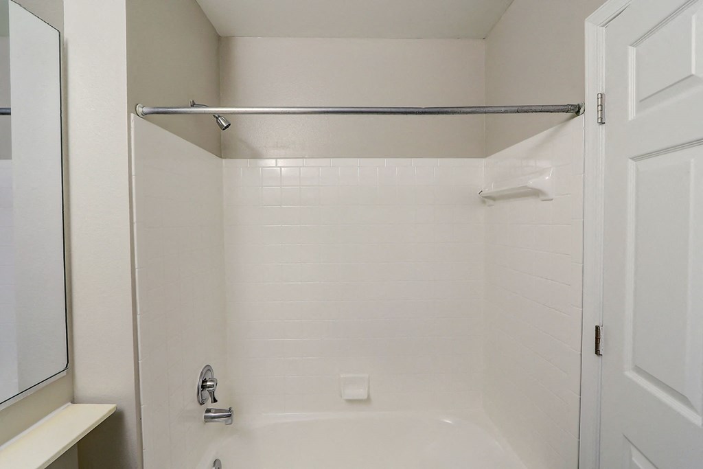 a white bathroom with a shower and a sink