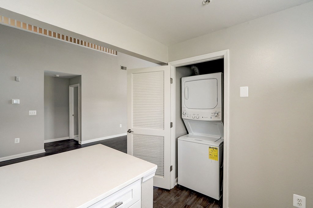 an empty kitchen with a washer and dryer and a laundry closet
