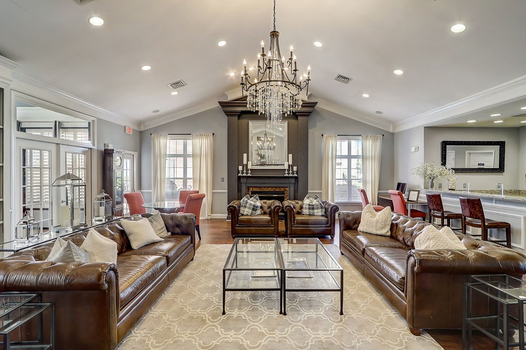 a living room with leather couches and a chandelier