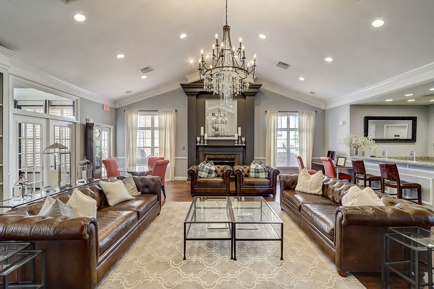 a living room with leather couches and a chandelier - Photo Gallery