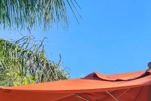 Two gas grills Table with umbrella and four chairs next to two, outdoor gas grilles - Photo Gallery