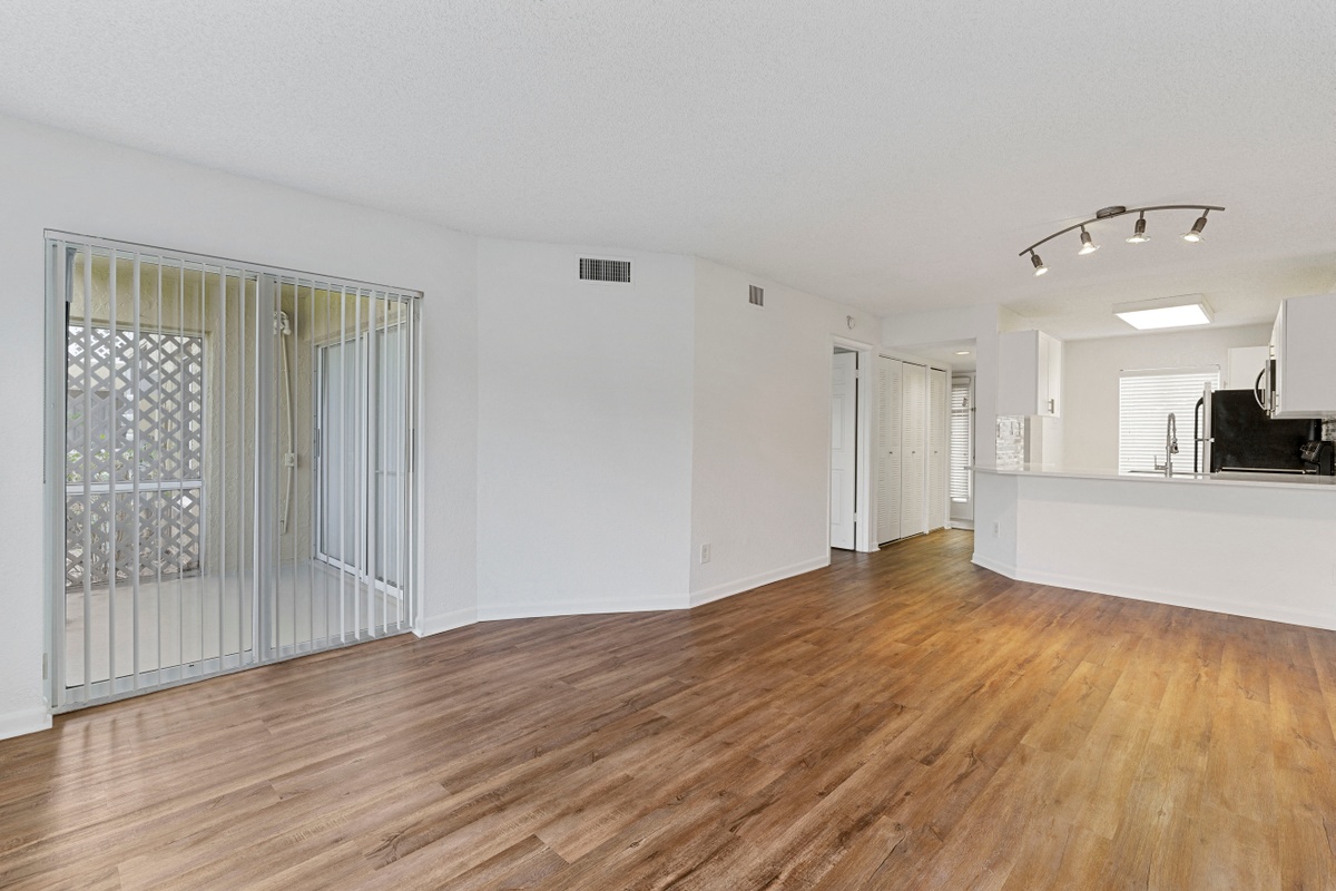 Living room with balcony door looking into kitchen