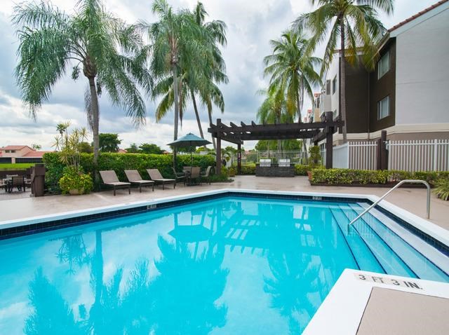 a large blue swimming pool with palm trees