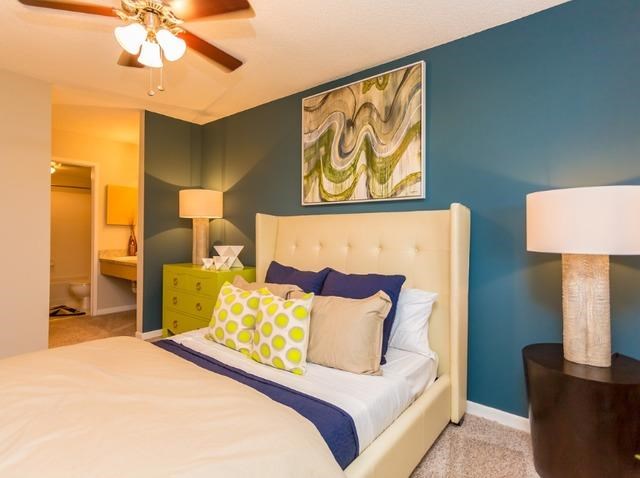 a bedroom with a large bed and a ceiling fan