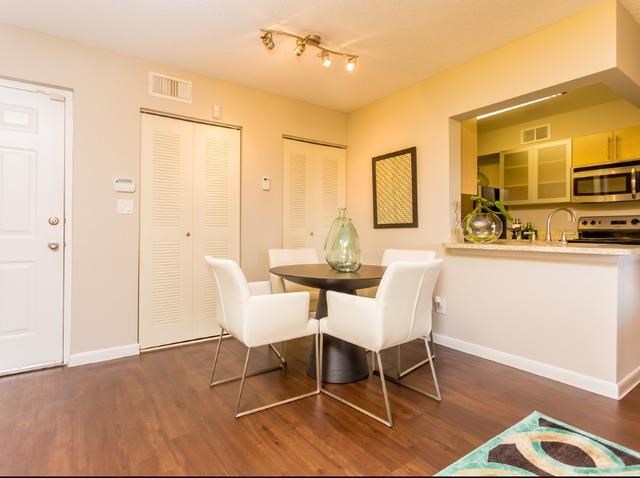 a dining room with a table and white chairs