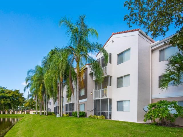 an apartment building with palm trees in front of it