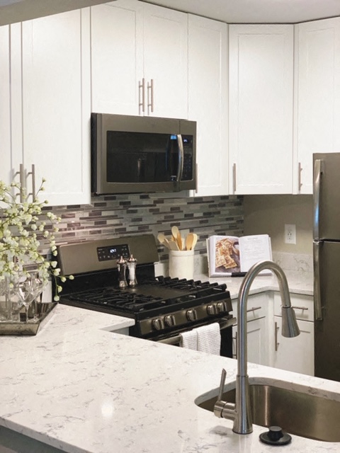 Kitchen area with sink, oven, microwave, and refrigerator