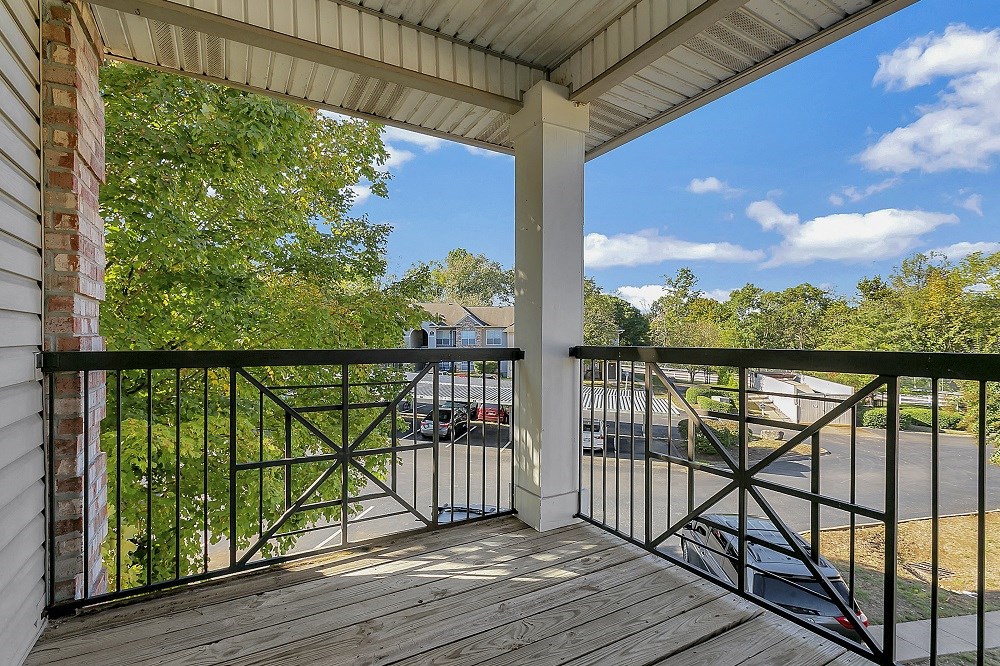 a balcony with a view of a street and trees