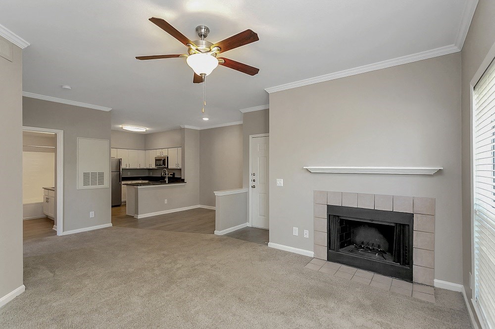 a living room with a fireplace and a ceiling fan