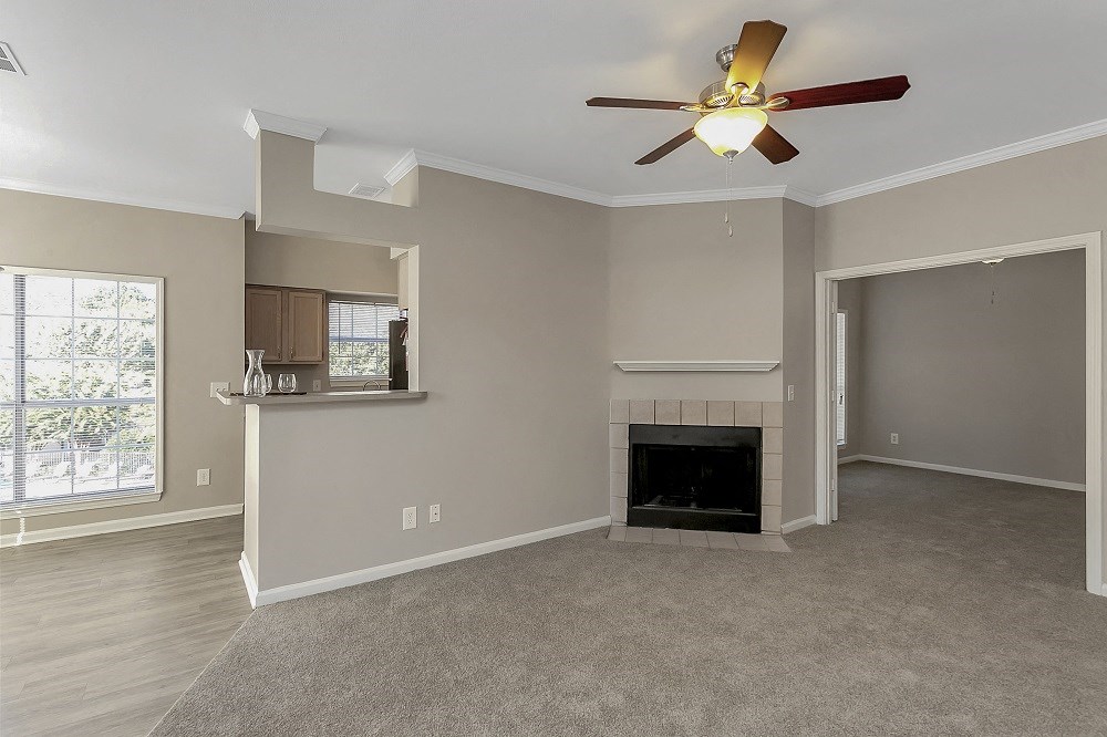 a living room with a fireplace and a ceiling fan