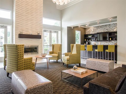 a living room with yellow chairs and a fireplace