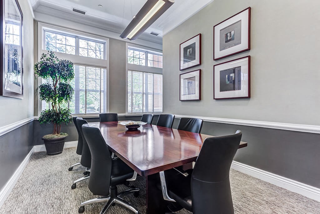 a conference room with a wooden table and black chairs