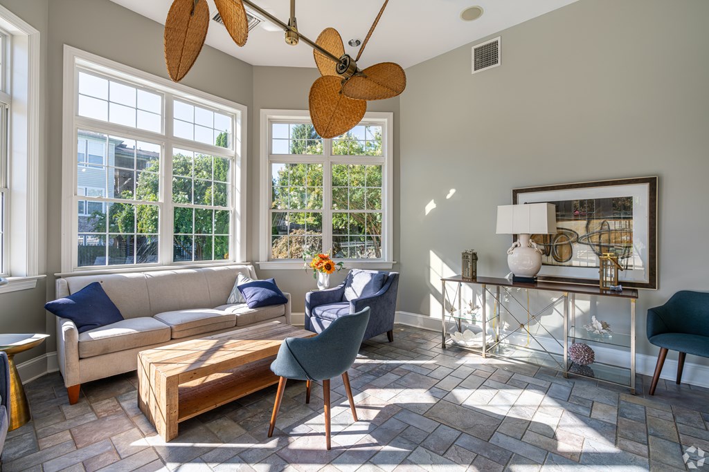 A living room with a couch, chair, and a fan.