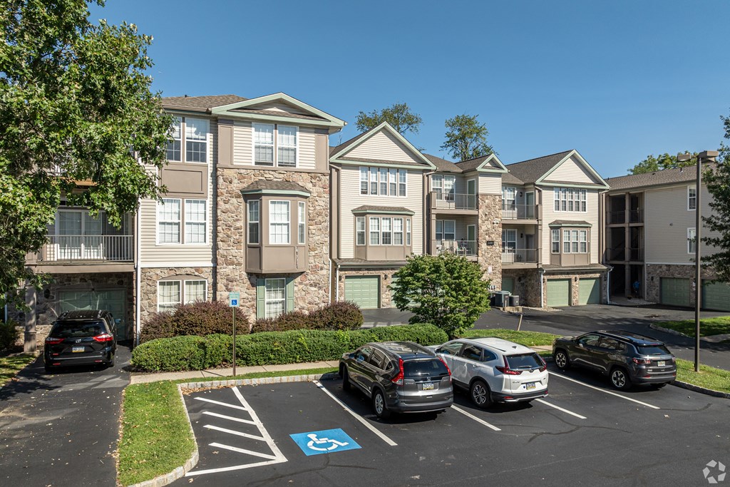 A parking lot with a handicap parking spot in front of apartment buildings.
