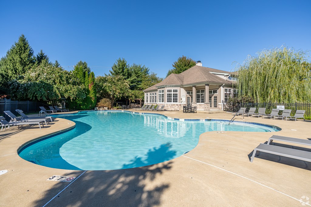 A large swimming pool with a building in the background.