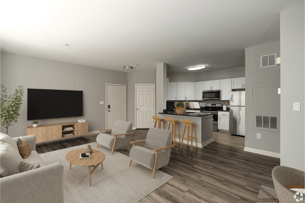 A modern living room with a flat screen TV and a kitchen in the background.