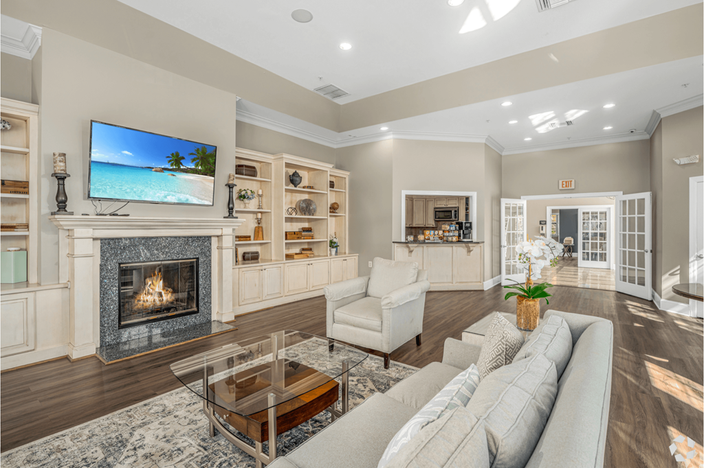 A living room with a fireplace and a flat screen TV mounted above it.