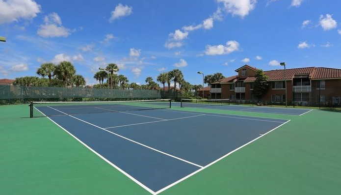Two Tennis court with building in background
