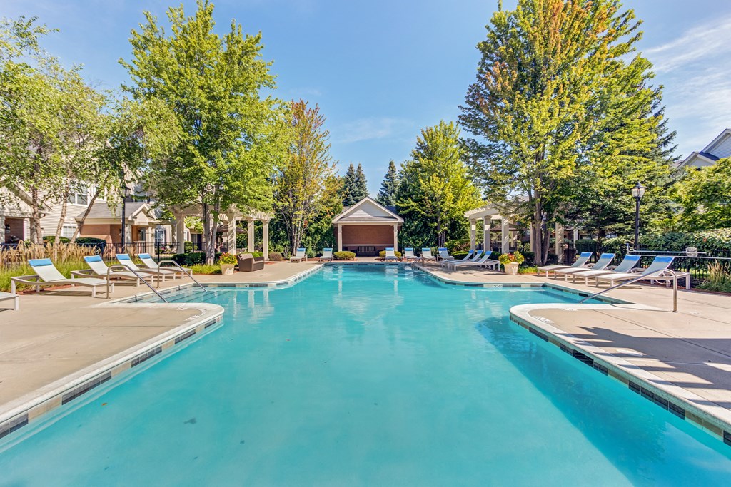 Aurora, IL Townhomes - The Apartments At Kirkland Crossing - Pool With Lounge Chairs And Trees Surrounding.