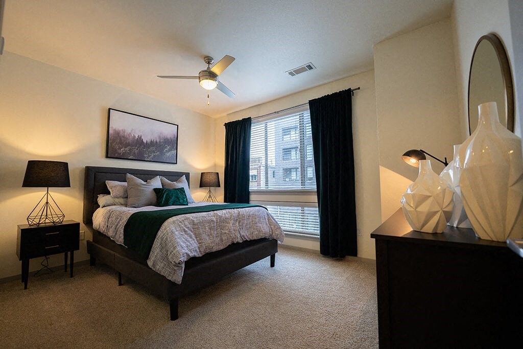 Pet Friendly Apartments in Denver CO - Line 28 LoHi - Blue Pool with Submerged and Poolside Lounge Chairs, Red Umbrella, Plant Boxes, and Building Exterior in Background