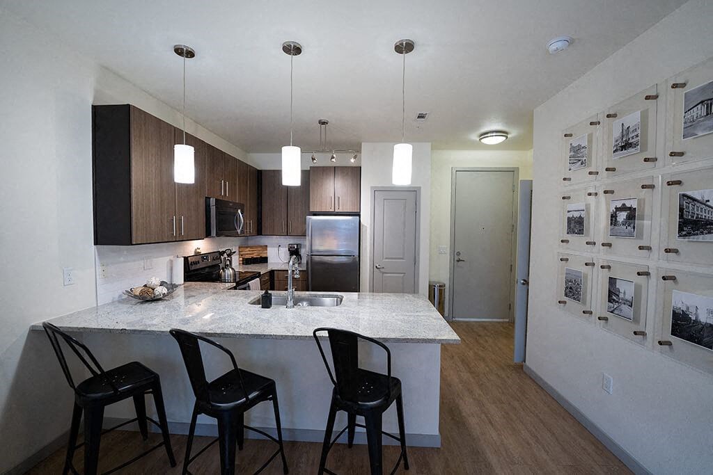 a kitchen with a marble counter top and black chairs