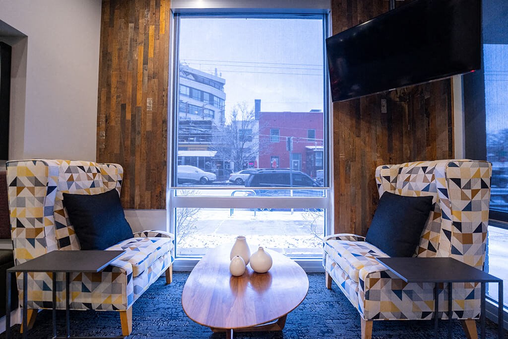 a living room with two chairs a table and a window