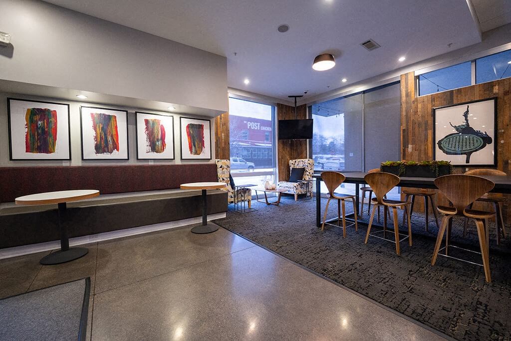a dining room with tables and chairs and paintings on the wall