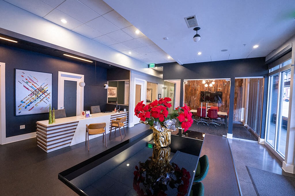 a conference room with a vase of red flowers on a table