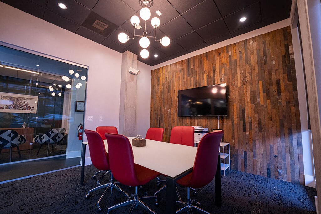 a conference room with a table and chairs and a tv