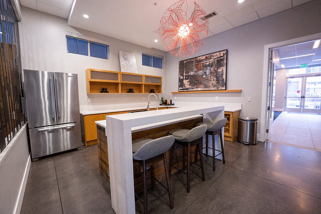 a kitchen with a bar and a stainless steel refrigerator