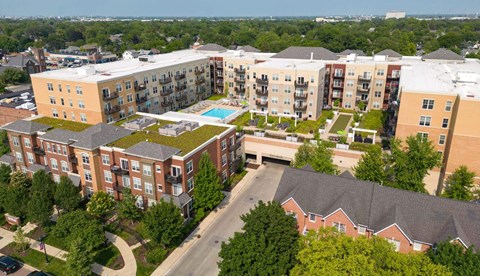 An aerial view of apartment buildings with a pool in the middle.