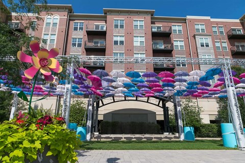 A large building with a white facade and balconies is surrounded by a colorful archway.