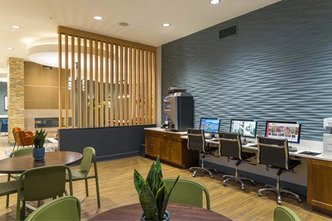 A modern office space with a wooden partition and multiple computer workstations.