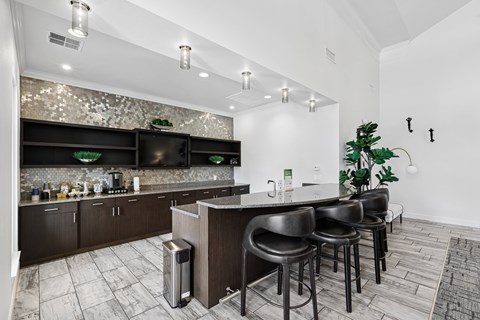 A modern kitchen with dark wood cabinets and a bar area.
