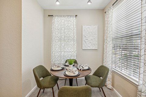 A dining room with a round table and four chairs.