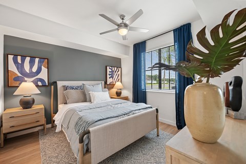 A bedroom with a bed, nightstands, and a ceiling fan.