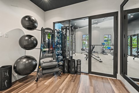 A gym room with a variety of equipment including a treadmill, weights and a rowing machine.