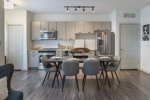 A modern kitchen with a dining table set for four.