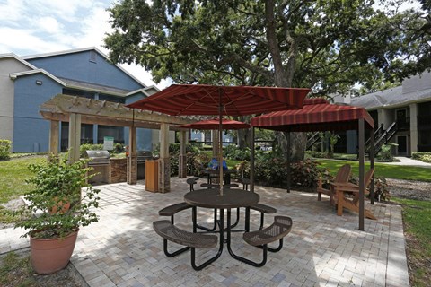 A patio with a table and chairs under a red canopy.