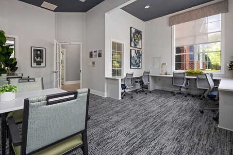 A room with a carpeted floor and white walls has a desk with a chair in front of it.