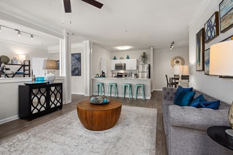 A living room with a grey couch and a wooden coffee table.