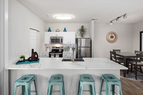Kitchen with bar seating and dining table at The Residences at Wakefield apartments in Raleigh, NC