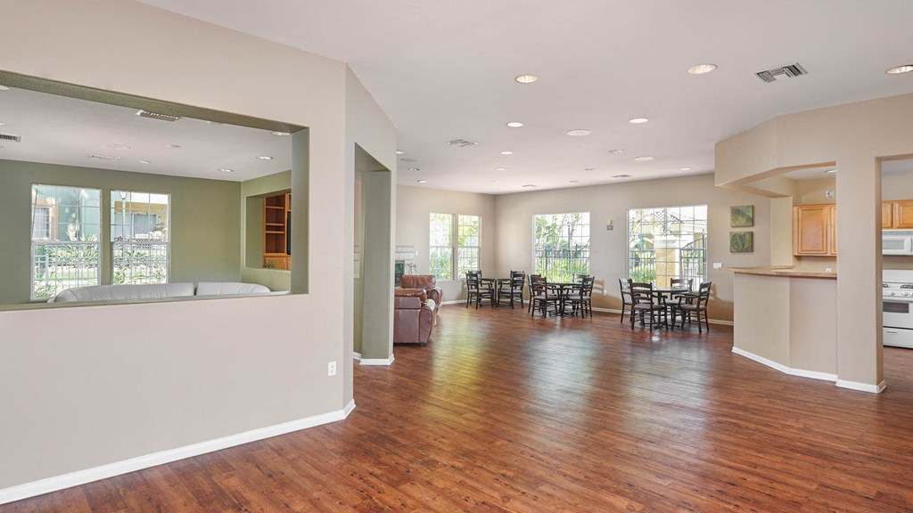 A large open living room with a dining area and kitchen in the background.