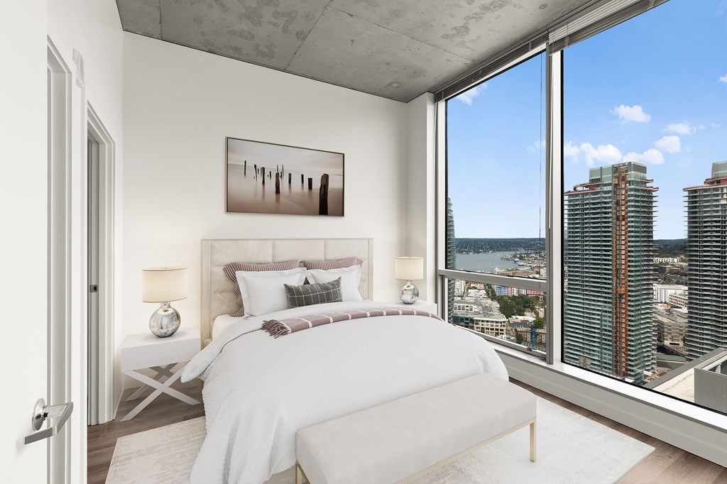 A bedroom with a large bed and a view of the city.