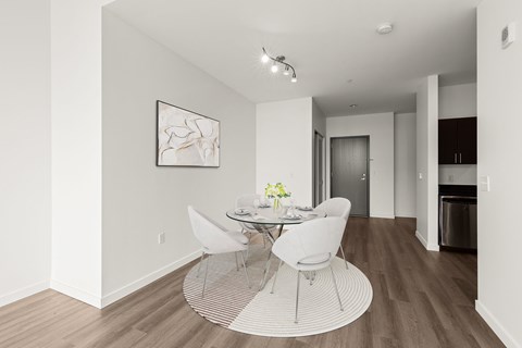 A dining room with a white table and chairs.