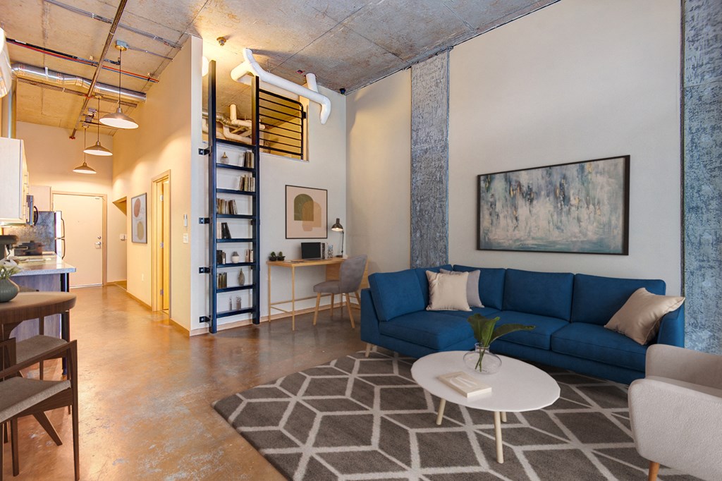A living room with a blue couch and a white coffee table.