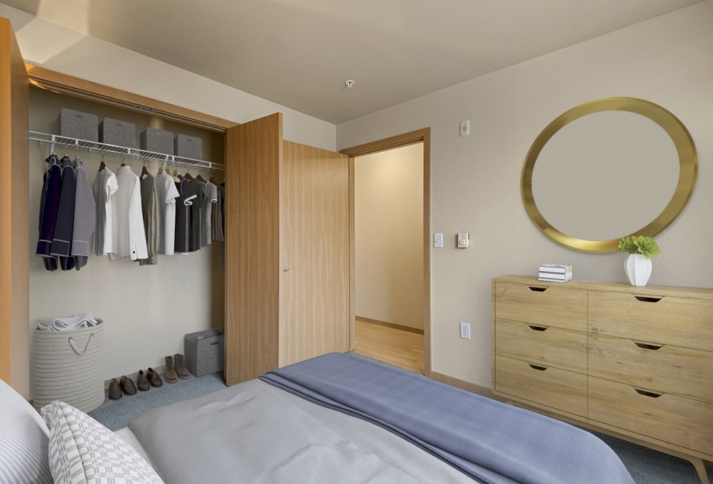 A bedroom with a bed, dresser, and closet.