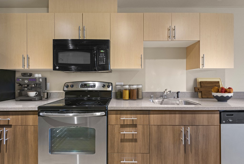 A modern kitchen with wooden cabinets and stainless steel appliances.