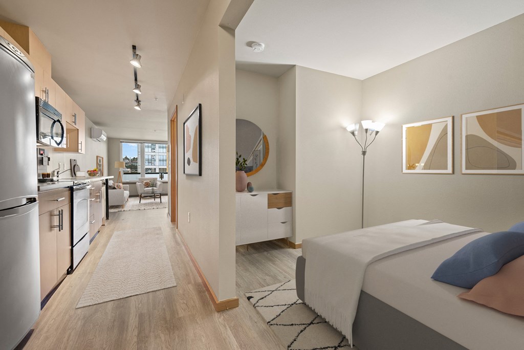 A modern bedroom with a large bed and a kitchen area.