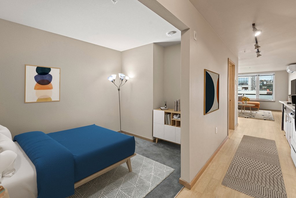 A living room with a blue sofa and a painting on the wall.